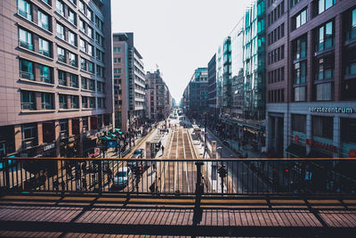 Footbridge in city against clear sky