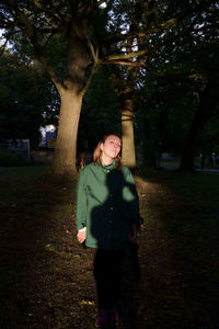 Portrait of man standing on tree trunk