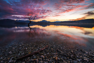 Scenic view of lake against sky at sunset