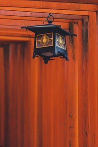 Low angle view of lighting equipment hanging on wall against building