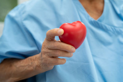 Midsection of woman holding heart shape