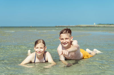 Portrait of smiling boy by sea against clear sky