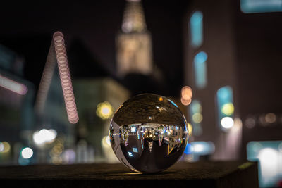 Close-up of illuminated crystal ball with reflection
