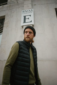 Young man standing outside building