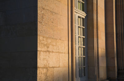 Golden hour, sunlight reflection on a stone wall and a window, lights and shadows