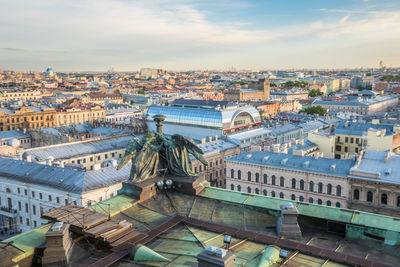 High angle view of city buildings against cloudy sky