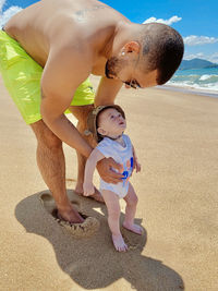 High angle view of boy playing on sand at beach