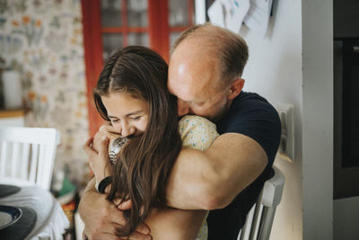 Loving father and daughter hugging at home