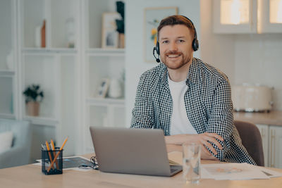 Portrait of smiling young man sitting at table