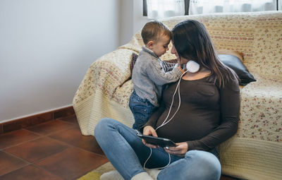 Mother looking at son while using digital tablet at home