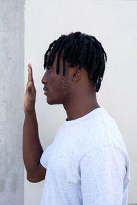 Black man making stop sign gesture next to the wall