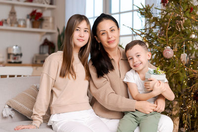 Family spends time together during christmas holidays in decorated house.