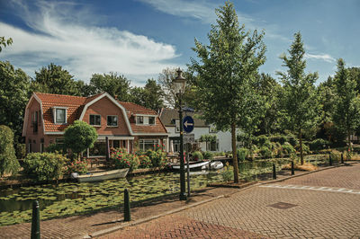 Houses by trees against sky in city