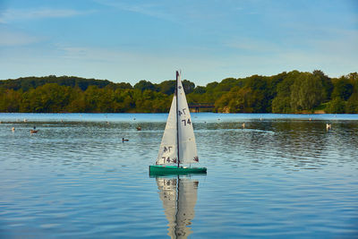 Sailboat on lake against sky