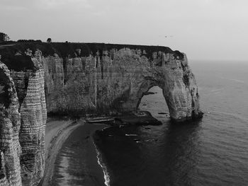 Panoramic view of rock formation in sea against sky