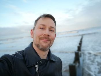 Portrait of smiling man against sea