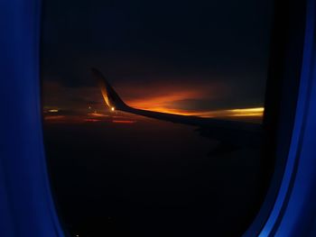 Cropped image of airplane flying over window