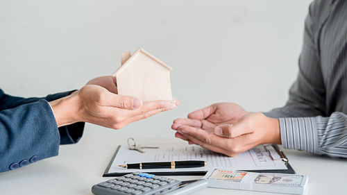 Midsection of couple holding paper with text on table