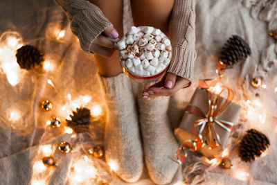 Woman hands holding a cup of coffee. cozy winter concept.hot chocolate or cocoa with marshmallow 