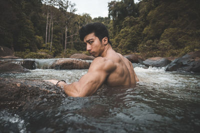 Portrait of muscular shirtless man in stream