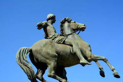 Low angle view of statue against clear blue sky