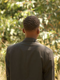 Rear view of man standing against plants