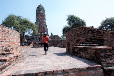 Full length of man standing on stone wall