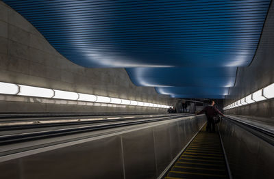 Man walking on escalator at railroad station