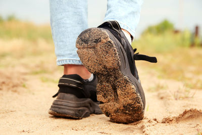 Fashion designer women's sneaker with high sole. female sports black shoe on sand desert background.