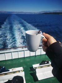 Cropped hand holding coffee cup