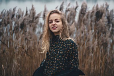 Portrait of young woman standing on field