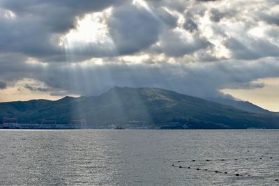 Scenic view of sea and mountains against sky