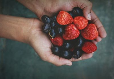 Close-up of hand holding strawberries