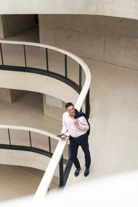 Contemplative businessman with tablet pc in corridor