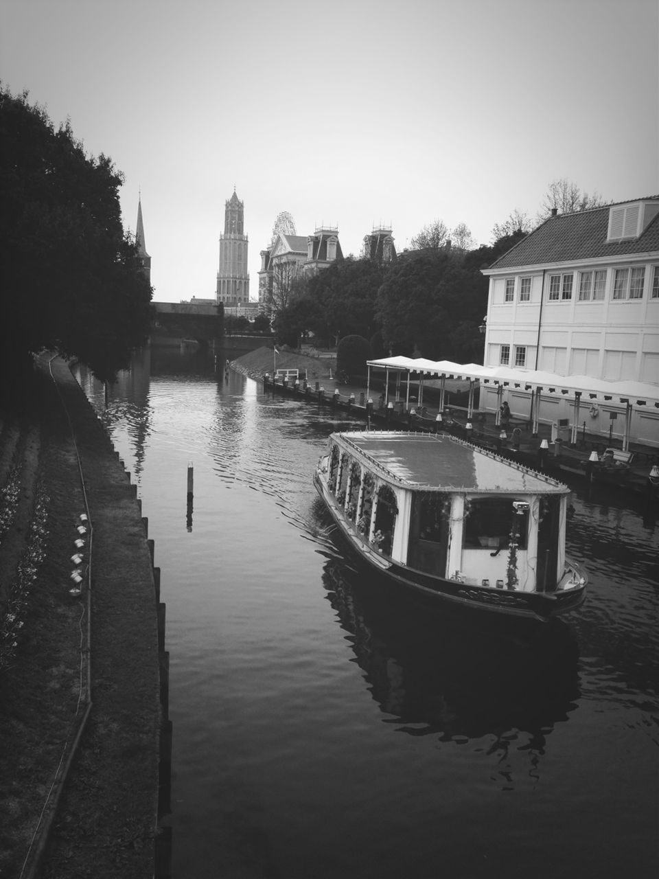 water, architecture, building exterior, built structure, nautical vessel, transportation, boat, clear sky, mode of transport, waterfront, canal, river, moored, reflection, city, incidental people, men, tree, day