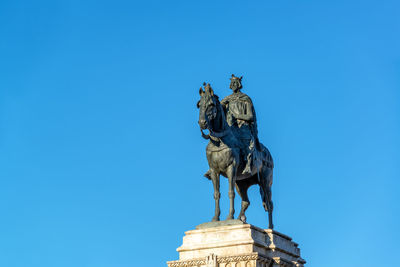 Low angle view of statue against blue sky