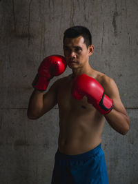 Shirtless male boxer against wall