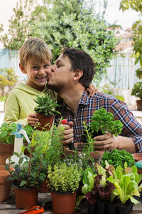 Happy friends holding plants