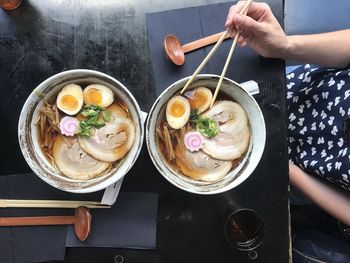 Woman eating japanese food with chopsticks.