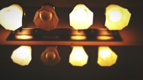 Close-up of lit light bulb at night