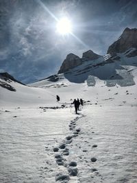 People on snow covered mountains against sky