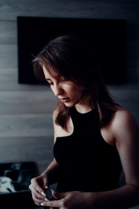 Young woman looking away while sitting on floor