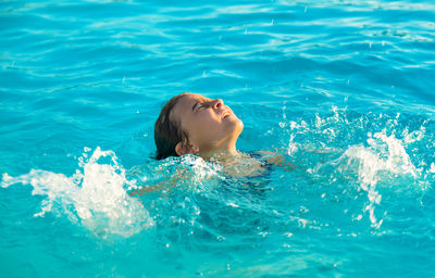 Cute girl drowning in swimming pool