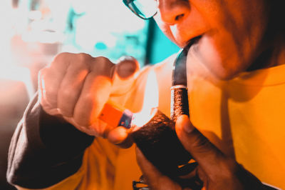 Midsection of man burning smoking pipe