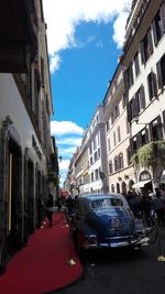 Buildings in city against cloudy sky