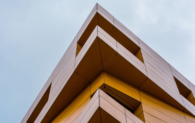 Low angle view of yellow building against sky