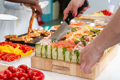 People holding food on cutting board