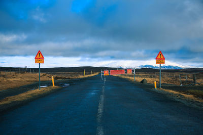 Road sign against sky