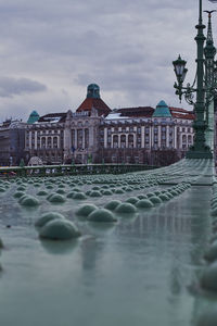 Water fountain in city against sky