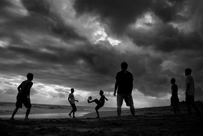 Silhouette of woman against cloudy sky